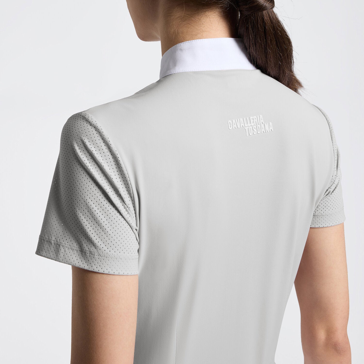 Close-up back view of a model wearing the gray Cavalleria Toscana Perforated Short Sleeve Competition Shirt on a plain background