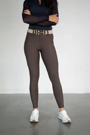 Front view of a female model wearing the brown Free Ride Lux Knee Patch Breeches in a studio setting