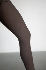 Close-up view of the silicone grip on the brown Free Ride Lux Knee Patch Breeches in a studio setting