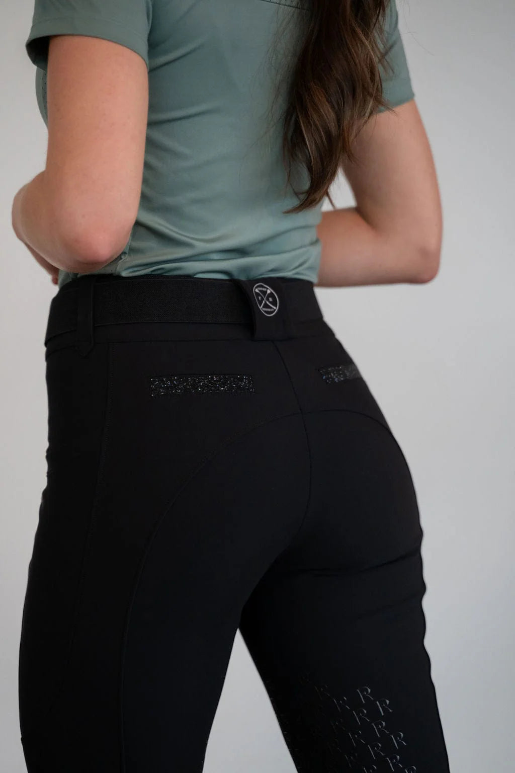 Back view of a model wearing the black Free Ride PRO Knee Patch Breeches in a studio setting