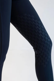 Close-up side view of a female model wearing the navy Free Ride PRO Full Seat Breeches on a plain background