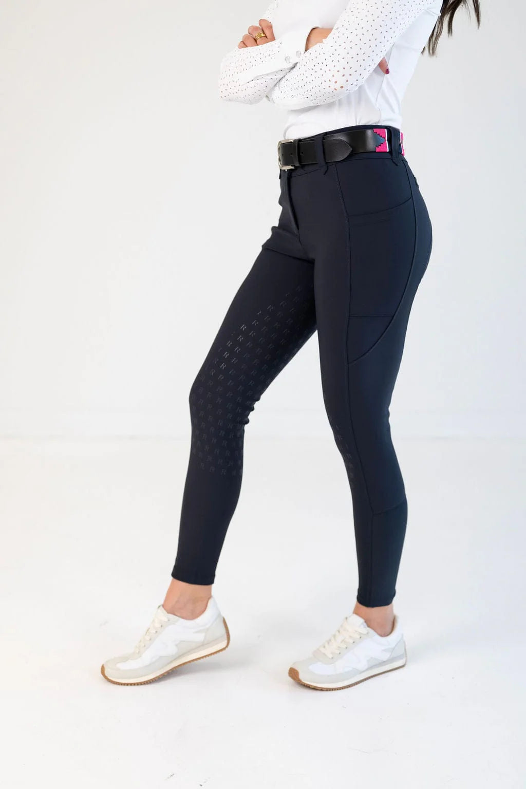 Side view of a female model wearing the navy Free Ride PRO Full Seat Breeches on a plain background