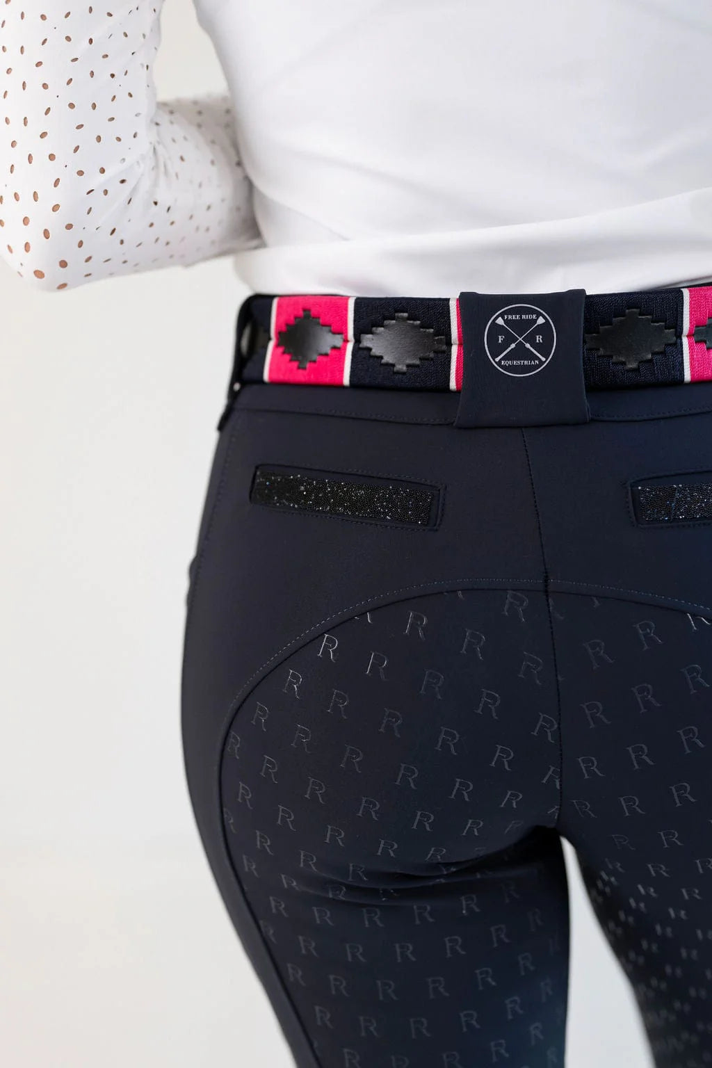 Close-up back view of a female model wearing the navy Free Ride PRO Full Seat Breeches on a plain background