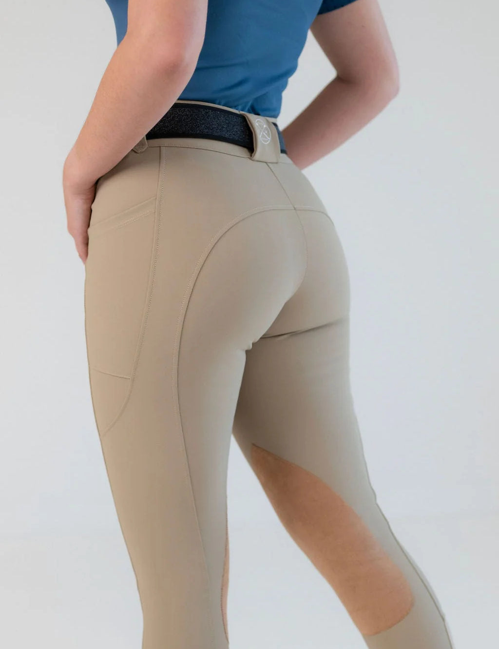 Angled back view of a model wearing the beige Free Ride PRO Knee Patch Breeches on a plain background