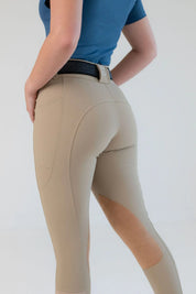 Angled back view of a model wearing the beige Free Ride PRO Knee Patch Breeches on a plain background