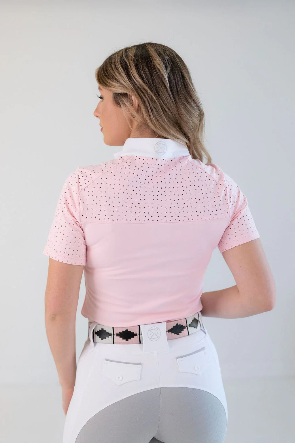 Back view of a female model wearing the pink Free Ride Cassidy Short Sleeve Show Shirt on a plain background