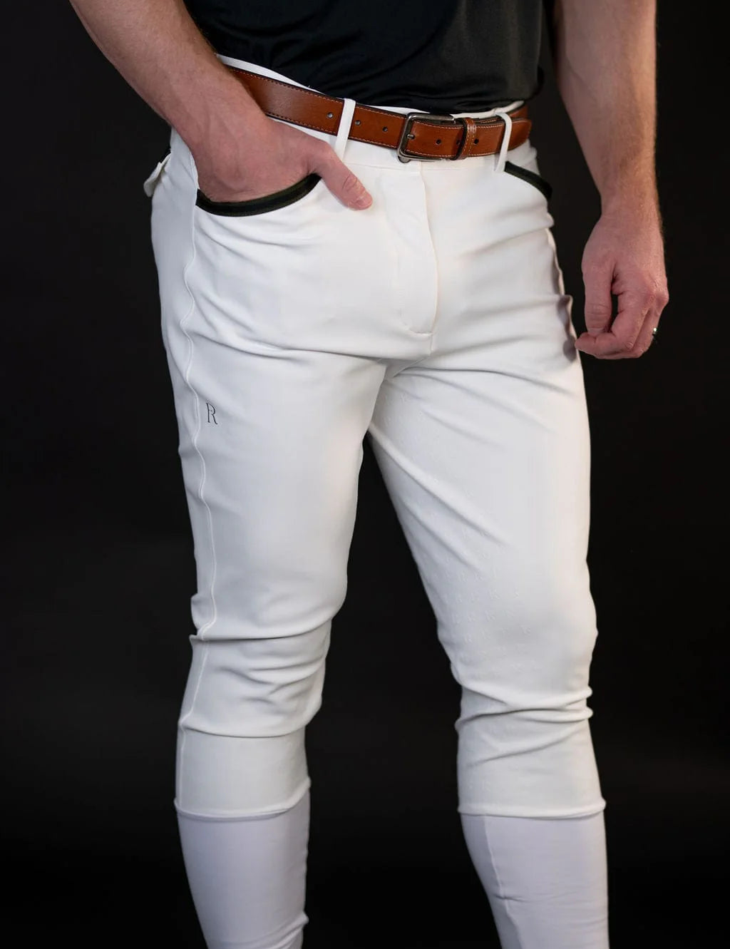Front view of a male model wearing the white Free Ride Men's PRO Knee Patch Breeches on a black background