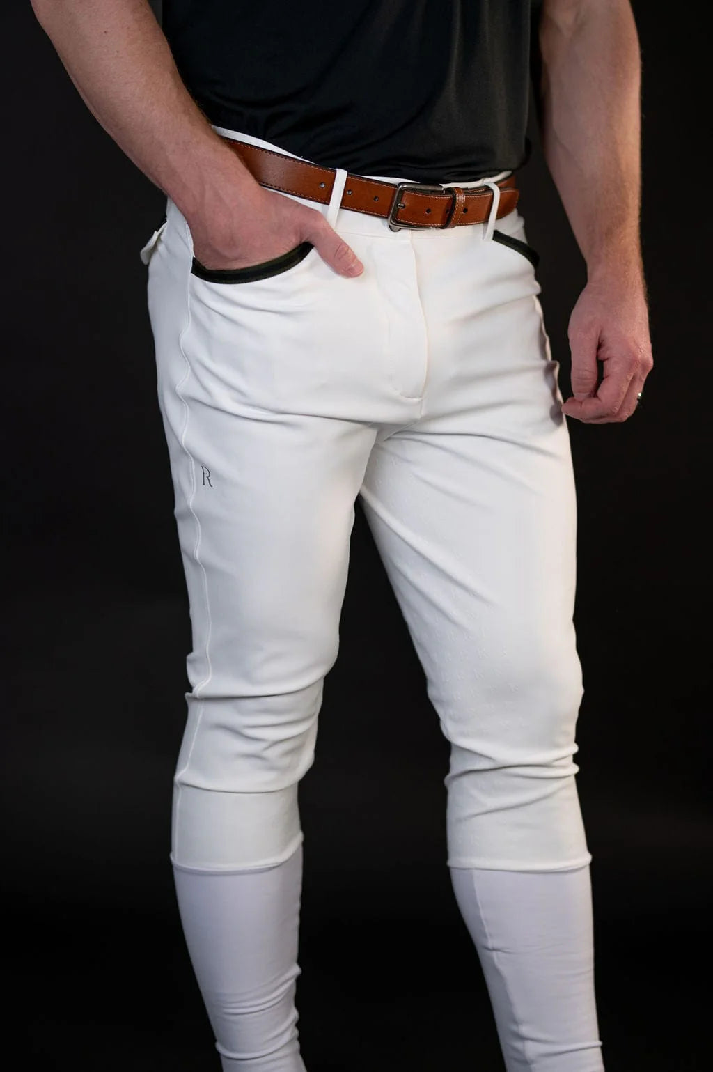 Front view of a male model wearing the white Free Ride Men's PRO Knee Patch Breeches on a black background