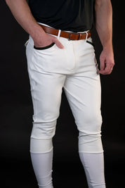 Front view of a male model wearing the white Free Ride Men's PRO Knee Patch Breeches on a black background