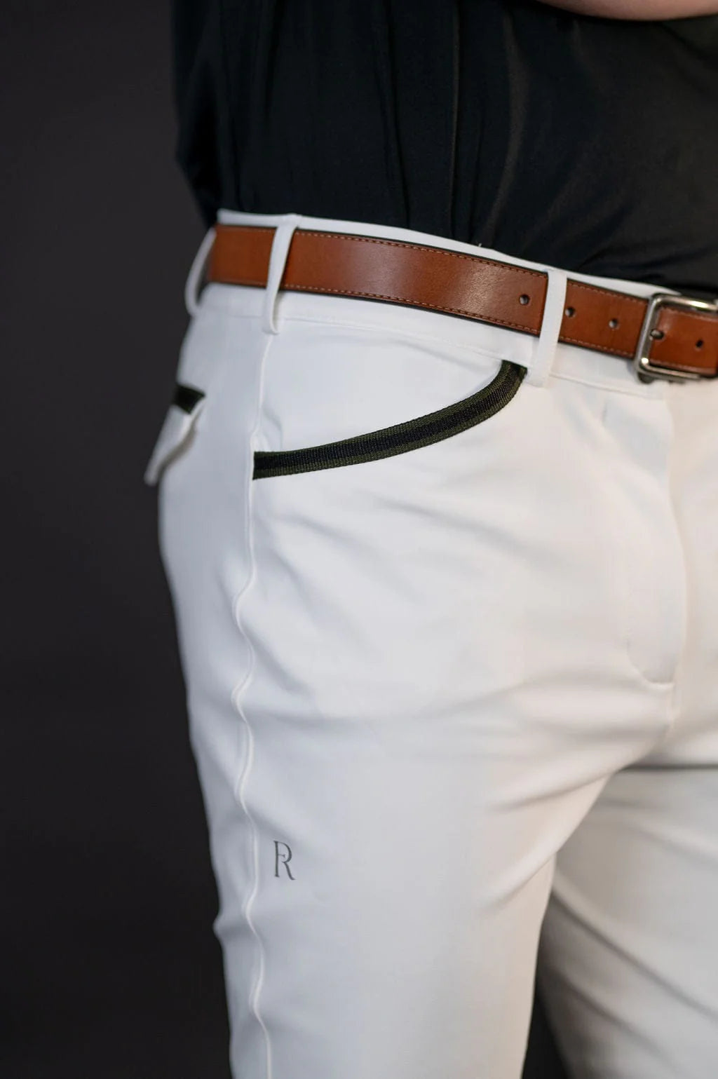 Close-up side view of a male model wearing the white Free Ride Men's PRO Knee Patch Breeches on a black background