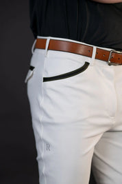 Close-up side view of a male model wearing the white Free Ride Men's PRO Knee Patch Breeches on a black background