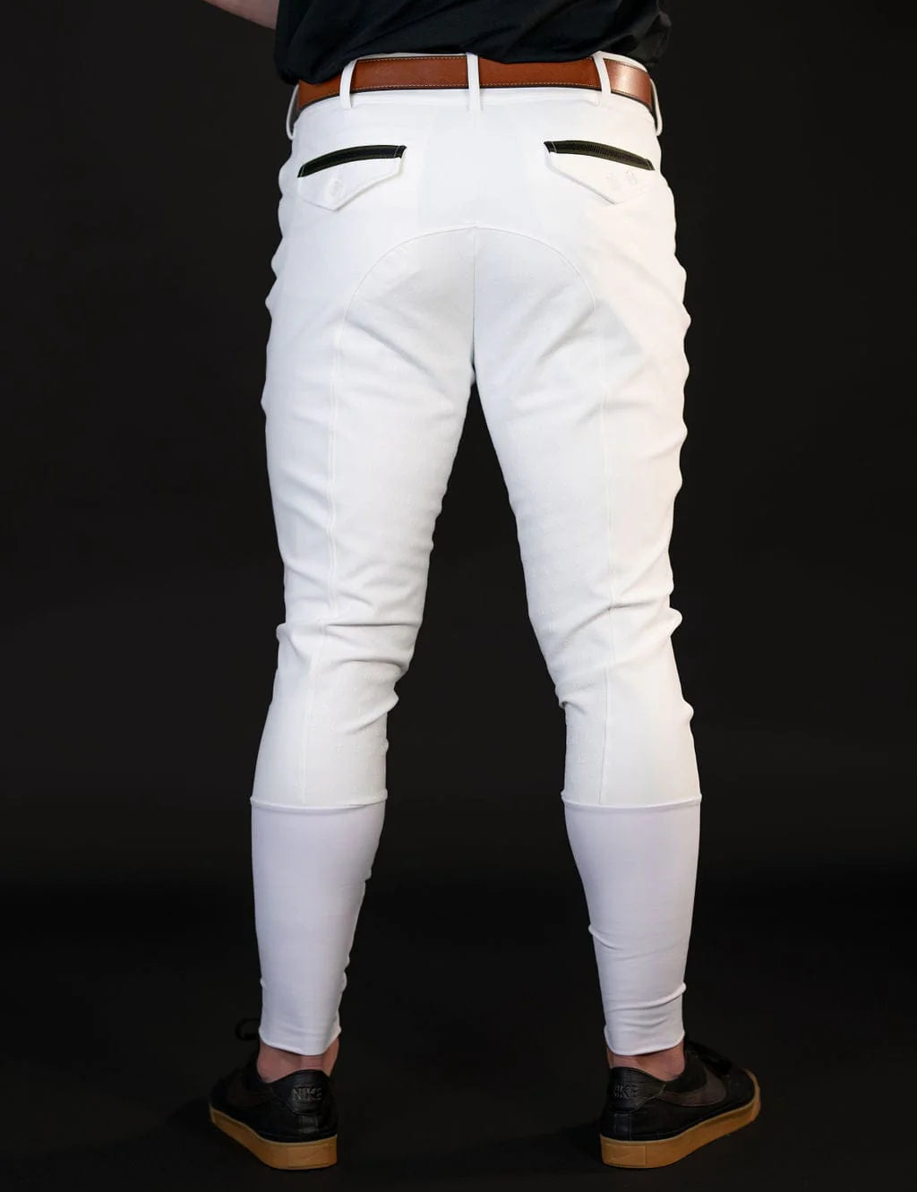 Back view of a male model wearing the white Free Ride Men's PRO Knee Patch Breeches on a black background