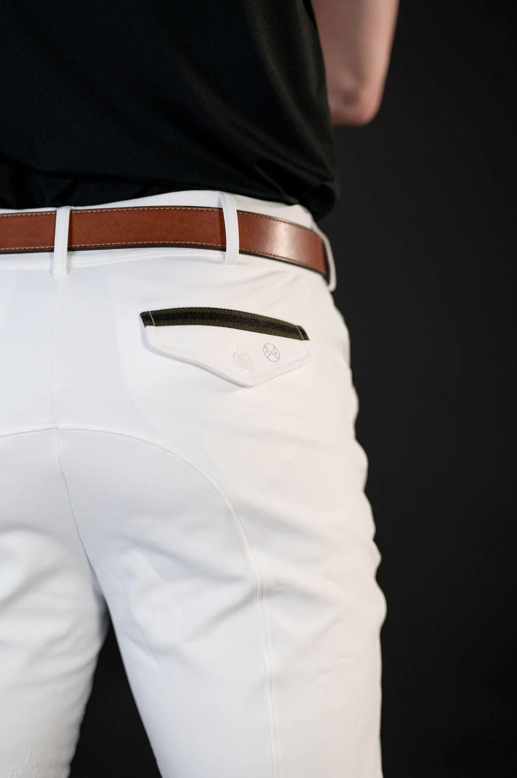 Close-up back view of a male model wearing the white Free Ride Men's PRO Knee Patch Breeches on a black background