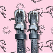 Close-up view of the Gray Horse Mane Jane Spur Straps on a pink equestrian background