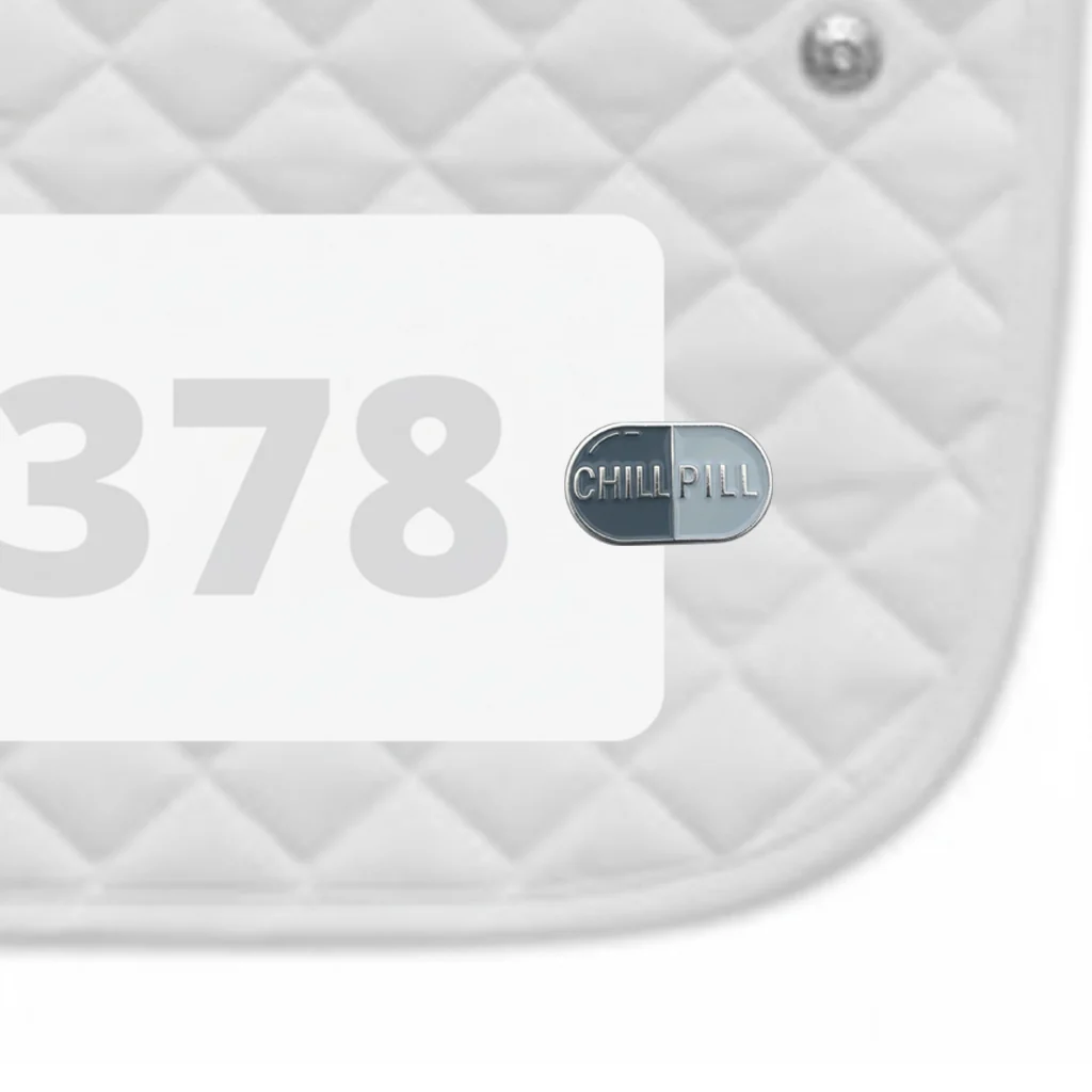 Side view of a white pad with numbers 378 and a Chill Pill Dubois Cheval Number Pin Charm on a white background