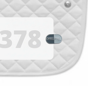 Side view of a white pad with numbers 378 and a Chill Pill Dubois Cheval Number Pin Charm on a white background