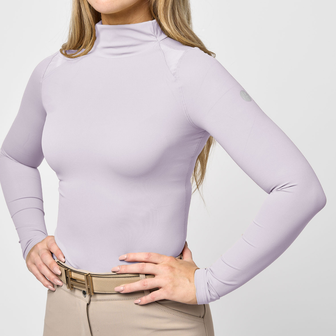 Front view of a female model wearing the Charm TKEQ Chloe High Collar Technical Top on a plain background