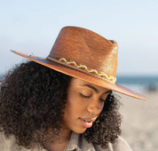 Angled front view of a female model wearing the Dorfman Milano Passiflora Hat with a blue sky background