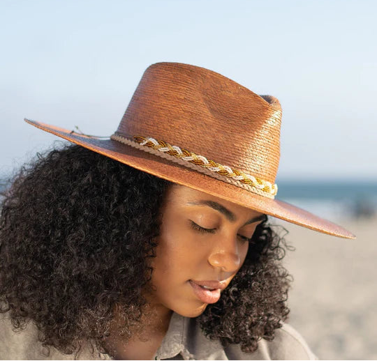 Angled front view of a female model wearing the Dorfman Milano Passiflora Hat with a blue sky background