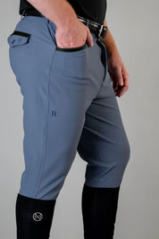 Side view of a male model wearing the navy Free Ride Men's PRO Knee Patch Breeches on a plain background