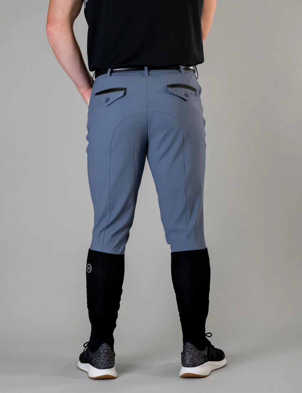Back view of a male model wearing the blue Free Ride Men's PRO Knee Patch Breeches on a plain background