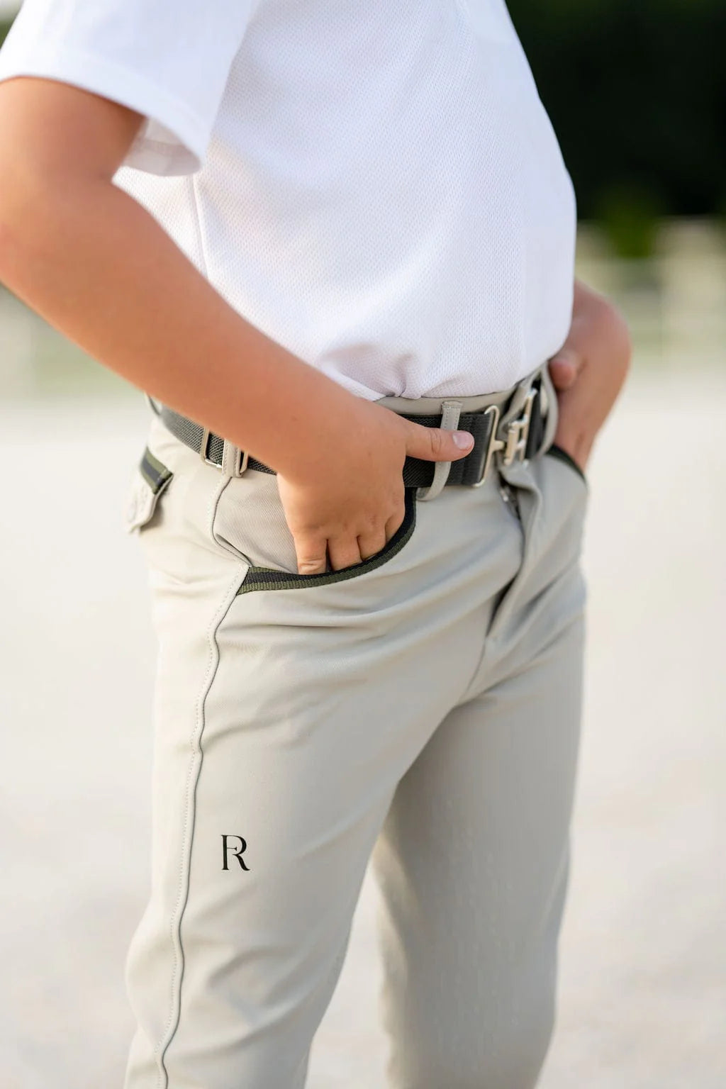 Close-up angled front view of a young male model wearing the beige Free Ride Boys Pro Knee Patch Breeches 