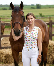 Front view of a female model wearing the Dancing Equestrian Lucky Dala Sleeveless Shirt while standing outside next to a horse