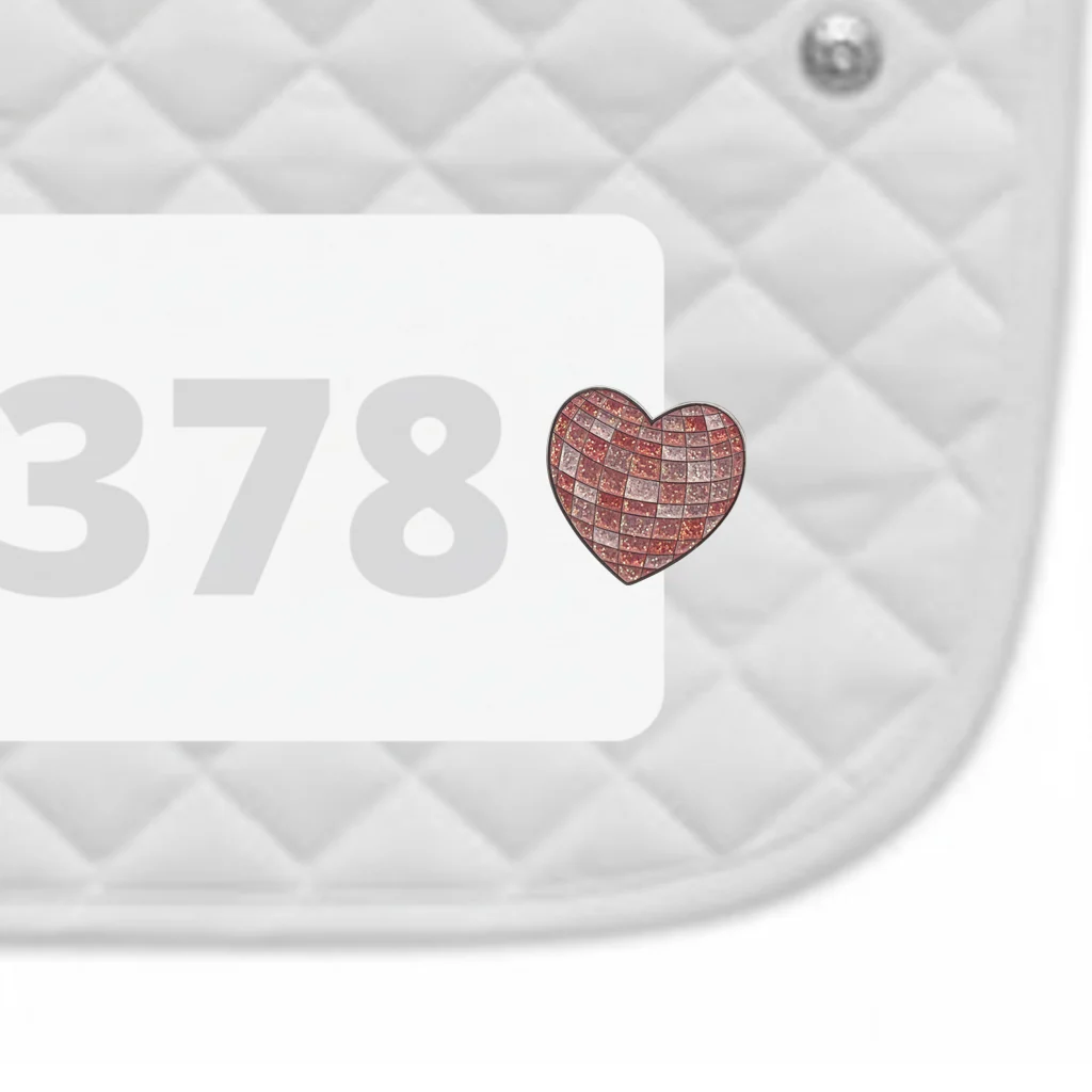 Side view of a white pad with numbers 378 and a Disco Heart Dubois Cheval Number Pin Charm on a white background