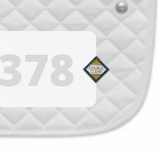 Side view of a white pad with numbers 378 and a Double Clear Dubois Cheval Number Pin Charm on a white background