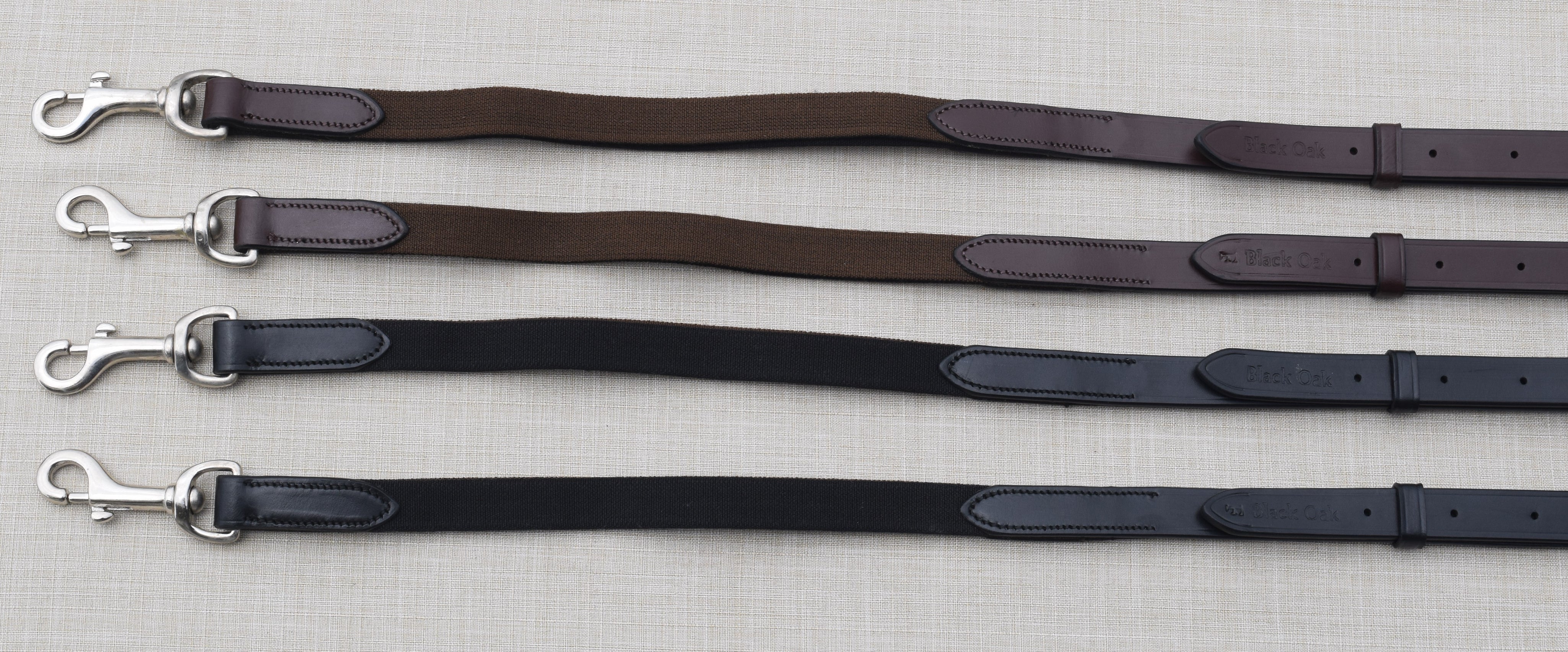 Side-by-side views of black and brown pairs of the Black Oak Elastic Side Reins on a textured background