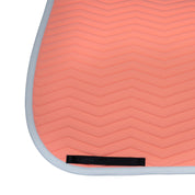 Close up view of the black girth keeper on the Equestro Wave Quilting Dressage Saddle Pad in a coral color on a white background