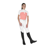 Full body front view of young model wearing the Girls' Slim Fit Competition Polo Shirt With Perforated Fabric in white and pink, white breeches, and black tall boots on a white background