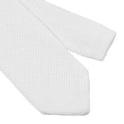 Close up view of the tip of the Equestro Men's Logo Tie in white on white background