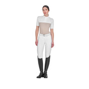 Full body view of model wearing the Equestro Women's Slim Fit Polo Shirt In Technical Fabric And Mesh in tan, white breeches, and black tall boots and white on a white background