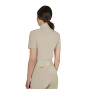 Back view of model wearing the Equestro Women's Slim Fit Training Polo Shirt With Zip And Collar Beads in tan on white background