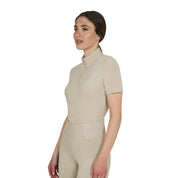 Angled front view of model wearing the Equestro Women's Slim Fit Training Polo Shirt With Zip And Collar Beads in tan on white background