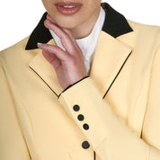 Close up front view of sleeve cuff and lapel of the Equestro Women's Competition Jacket With Zip And Buttons in yellow