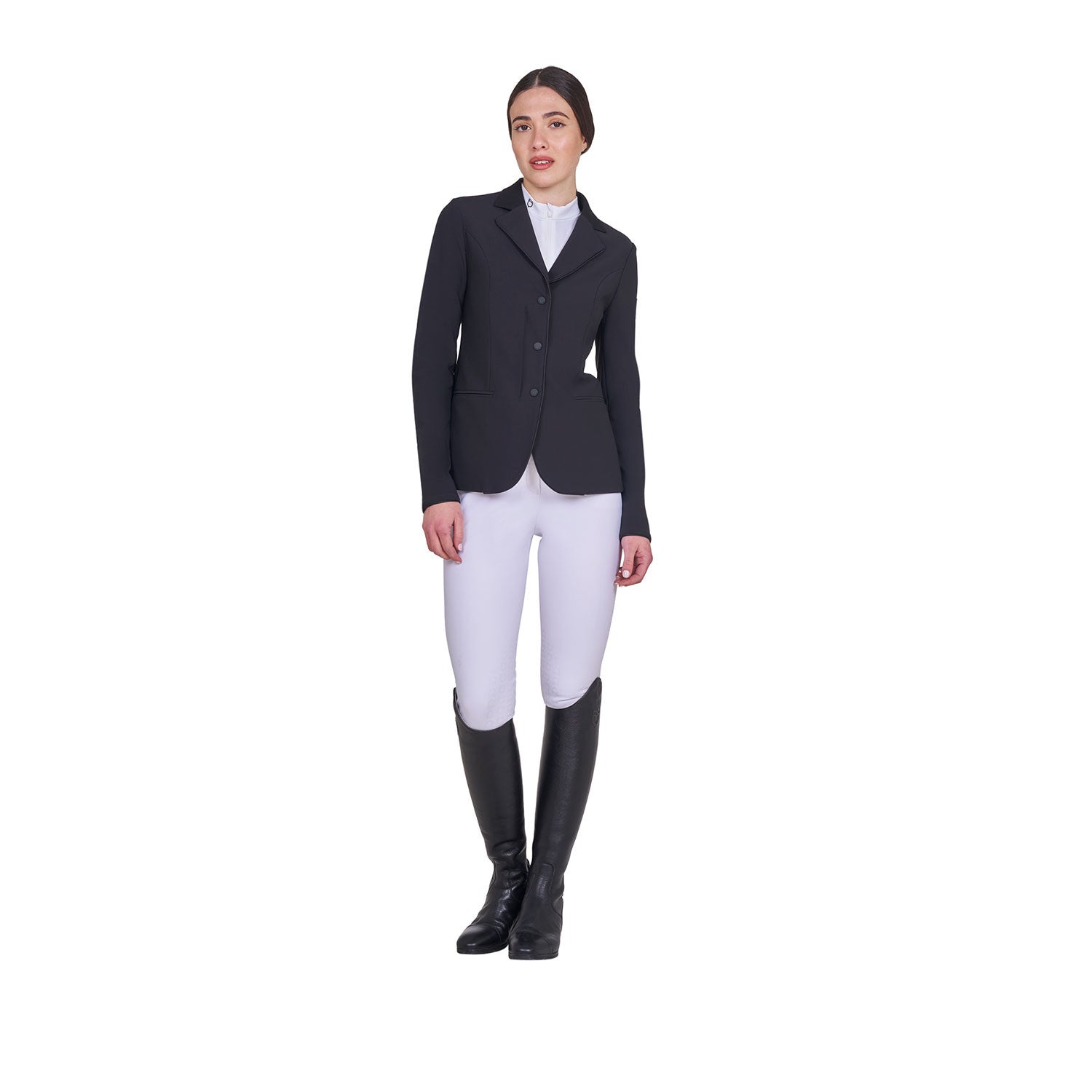 Full body front view of model wearing the Equestro Women's Competition Jacket With Zip And Buttons in black, white breeches, and black tall boots on a white background