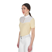 Angled front view of model wearing the Equestro Women's Slim Fit Competition Polo Shirt With Silk-Like Fabric Inserts in white and yellow on a white background