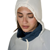 Close up view of model wearing the white hood of Equestro Women's Water-Repellent Outerwear in ombre navy and white on a white background