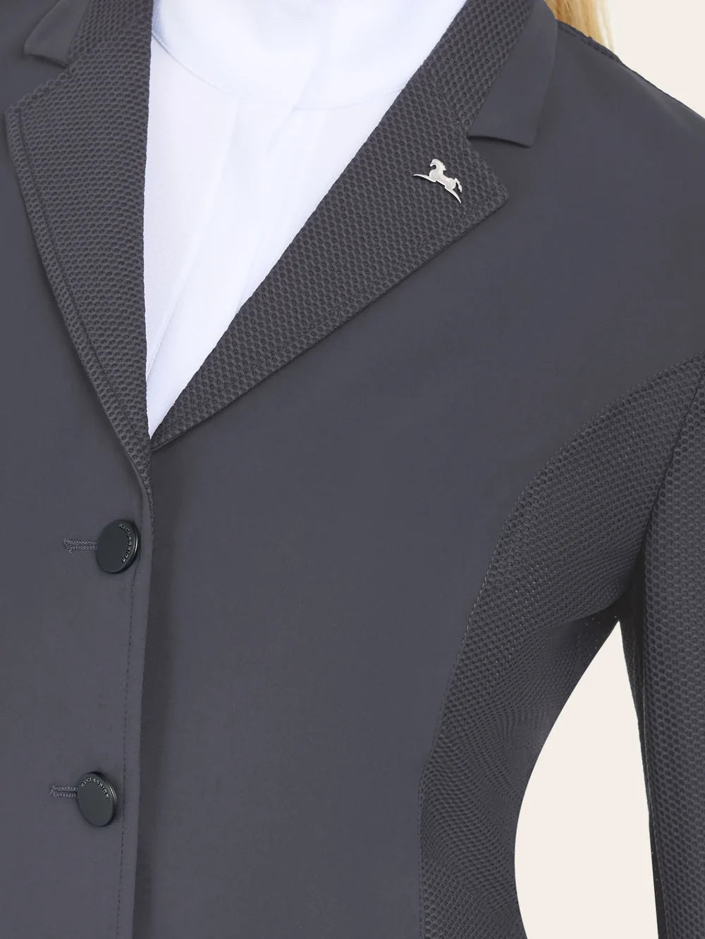 Close-up of the RJ Classics Harmony Evo Jr. Mesh Show Coat in Odyssey Grey highlighting the notched lapel in textured mesh, smooth front body panel, logo pin at the chest, and three-button front closure over a white show shirt.