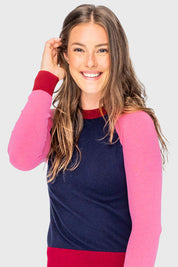 Front view of a female model wearing the navy, hot pink, and wine Kastel Crewneck Sweater on a plain background