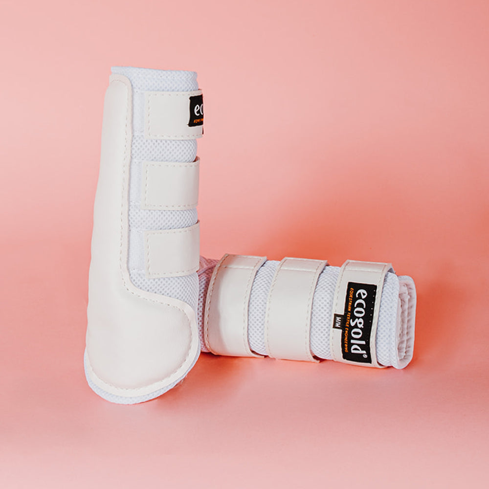 View of a pair of white Ecogold Breathable Exercise Horse Boots on a pink background
