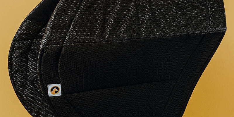 Side view of the black Ecogold Secure Cross Country Pad on a yellow background
