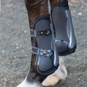 Close-up side view of a horse wearing the black Professional's Choice Pro Performance Open Front Boots while standing on arena footing