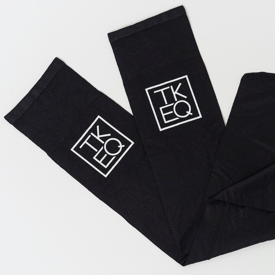 View of a pair of black TKEQ Logo Boot Socks on a white background