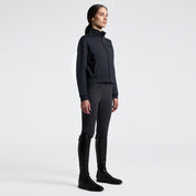 Angled front full length view a model wearing the Cavalleria Toscana Jersey Zip Sweatshirt in Charcoal, dark colored breeches, and black tall boots.