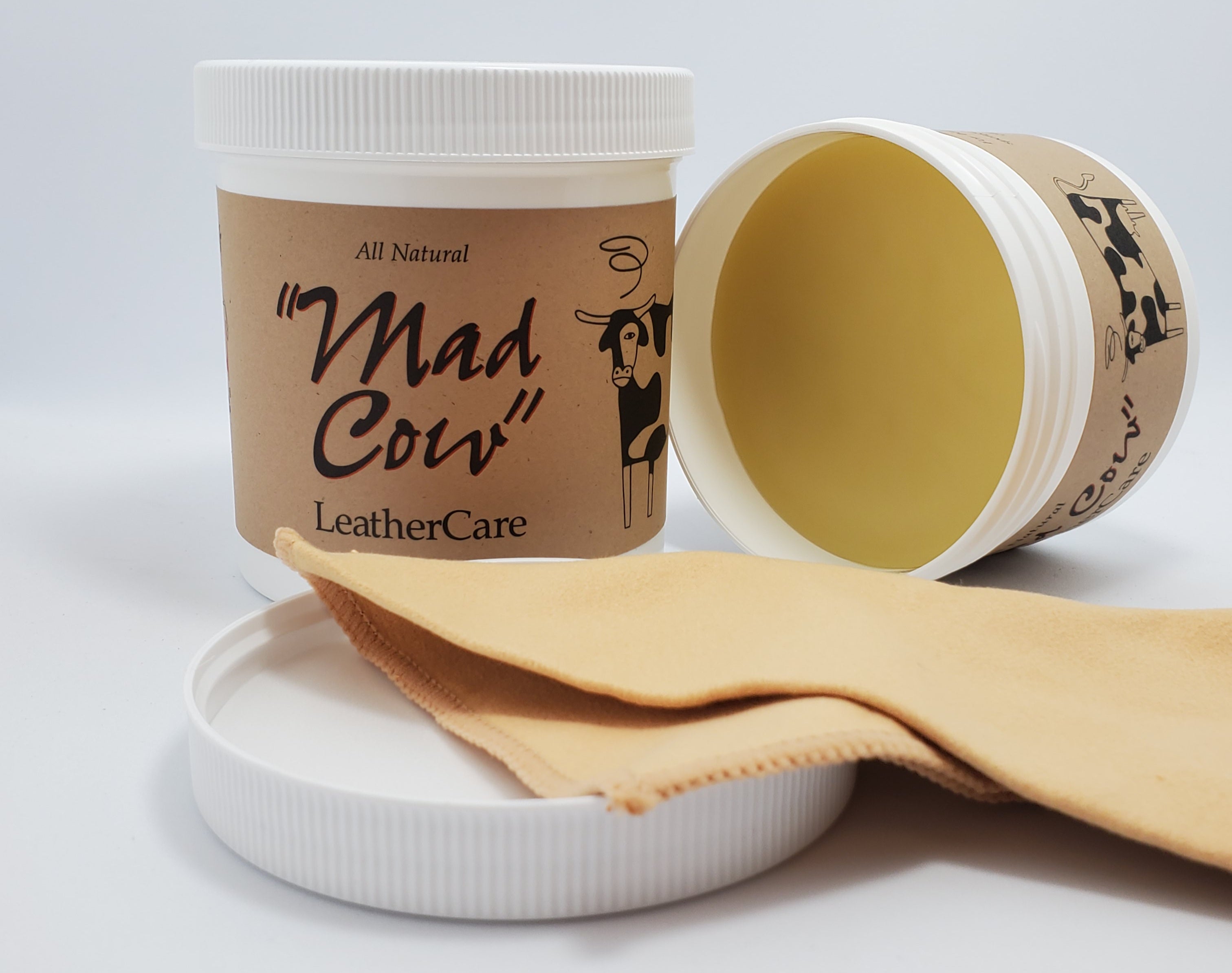 Front views of one closed jar and one open jar of Mad Cow Leather Care on a plain background