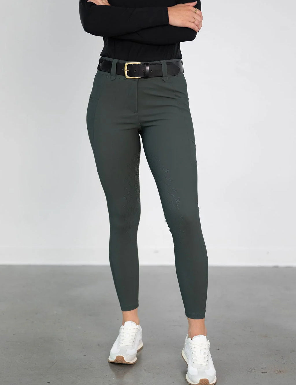 Front view of a model wearing the green Free Ride PRO Knee Patch Breeches in a studio setting