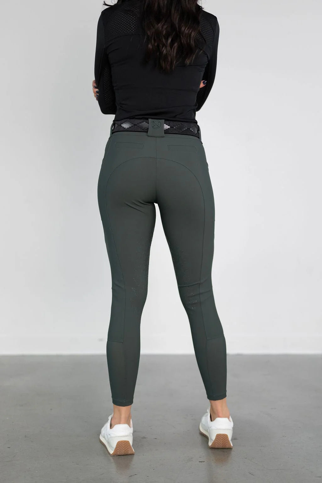 Back view of a model wearing the green Free Ride PRO Knee Patch Breeches in a studio setting